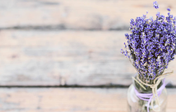 Bouquet of dried lavender in a glass pot on an old painted woode - Photo, Image