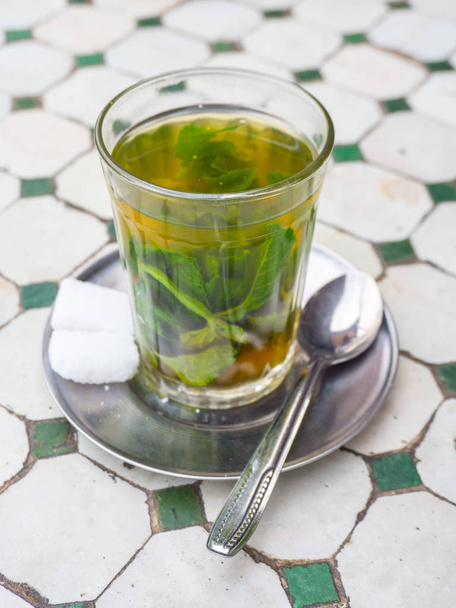 Authentic Moroccan mint tea in a glass cup isolated on table - Photo, Image