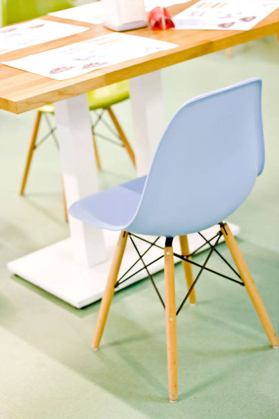 Пустой синий стул возле детского столика в кафе
 - Фото, изображение