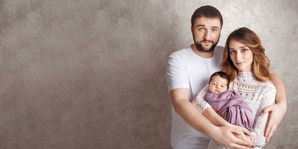 Woman and man holding a newborn. Mom, dad and baby.  Portrait of - Photo, Image