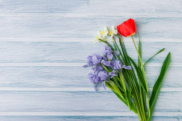 Spring flowers over light wooden background useful for greeting card, invitation, flyer and etc - Fotó, kép
