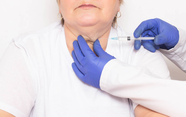 A doctor makes injections of ozone therapy and mesotherapy to a woman in a double chin to get rid of wrinkles and double chins, facial and skin rejuvenation, liposuction, serum - Φωτογραφία, εικόνα