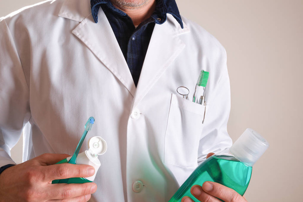 Стоматолог з інструментами для гігієни ротової порожнини та продуктами наполовину деталі тіла
 - Фото, зображення