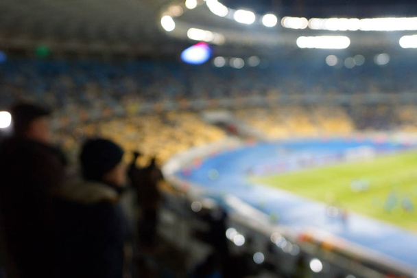 imagem desfocada do estádio de futebol em tempo crepúsculo para uso abstrato de fundo. - Foto, Imagem