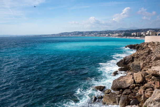 Nice, France, March 2019. Panorama. Azure sea, waves, English promenade and people resting. Rest and relaxation by the sea. On a sunny warm day, blue waves roll. - Foto, Bild