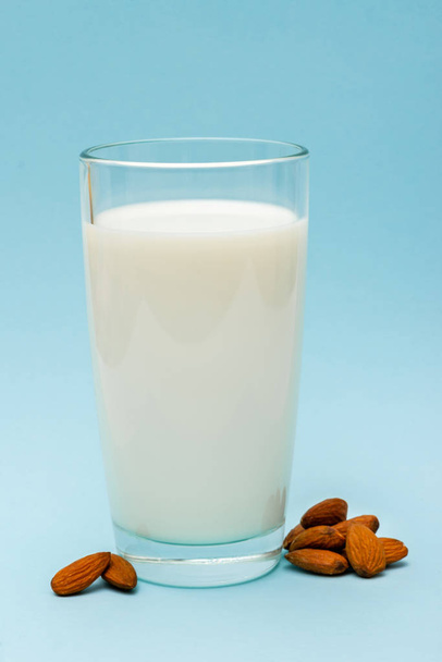 ποτήρι γάλα αμυγδάλου σε μπλε φόντο - Φωτογραφία, εικόνα