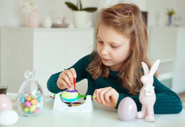 Cute little blonde girl painting Easter eggs - Foto, Imagen