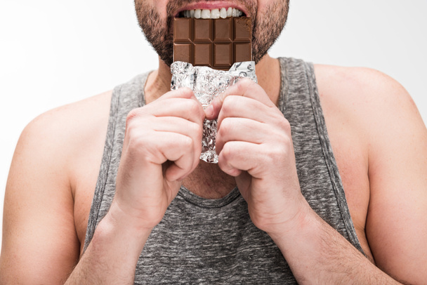 vista ritagliata di paffuto uomo mangiare cioccolato isolato su bianco
 - Foto, immagini