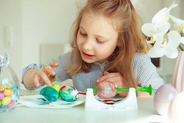 Cute little blonde girl painting Easter eggs - Foto, Imagem