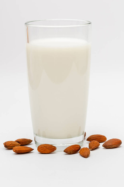Bicchiere di latte di mandorla su sfondo bianco
 - Foto, immagini