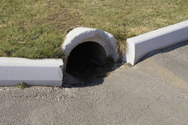 beton Csatornázási cső aszfalt a megfékezésére a gyep zöld fű - Fotó, kép