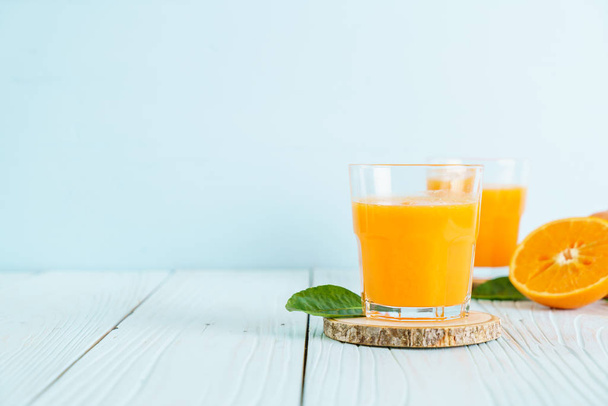 Fresh orange juice on wood background - Φωτογραφία, εικόνα