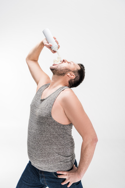 homem com sobrepeso pulverização chantilly na boca no branco
 - Foto, Imagem