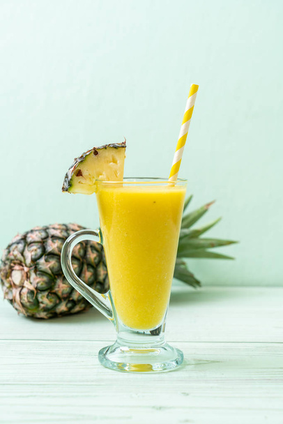 fresh pineapple smoothie glass on wood table - Valokuva, kuva