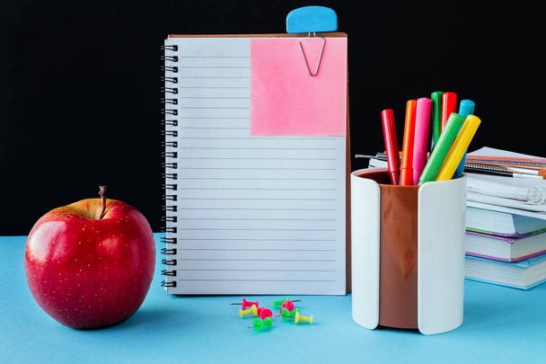 Шкільні аксесуари, блокнот, олівці, маркери, яблуко. Концепція назад до школи на чорному тлі з місцем для копіювання тексту
  - Фото, зображення