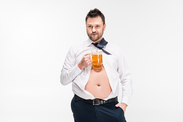 túlsúlyos férfi feszes ing kézzel zsebben gazdaság pohár sör izolált fehér - Fotó, kép