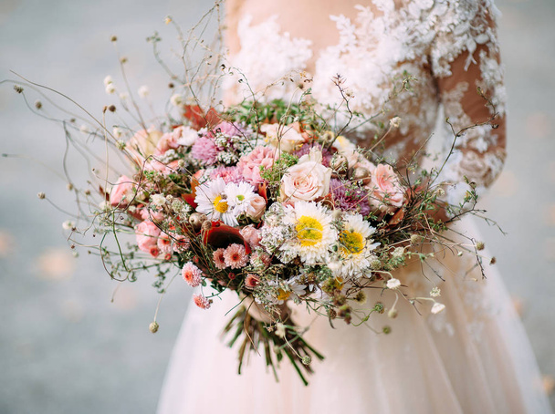 bride in white dress holding wedding bouquet with tender flowers - Foto, Imagen