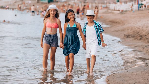Bambini felici che camminano insieme lungo il mare
 - Foto, immagini