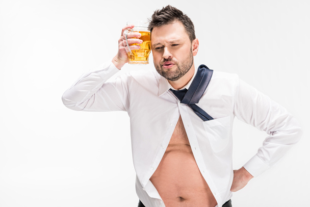 hombre con sobrepeso sosteniendo un vaso de cerveza cerca de la cara aislado en blanco
 - Foto, Imagen