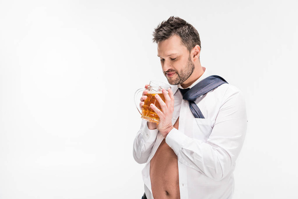 człowiek z nadwagą w ciasnej koszulce trzymając szklankę piwa na białym tle z kopią - Zdjęcie, obraz