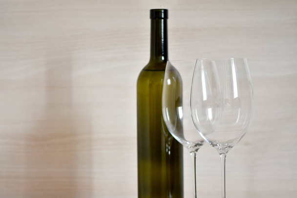 Μπουκάλι κρασί και ποτήρια κρασιού στο απλό εσωτερικό του διαμερίσματος - Φωτογραφία, εικόνα