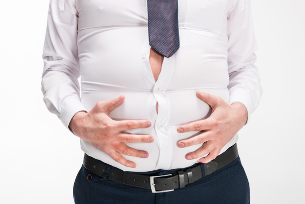 cropped view of overweight man in tight formal wear touching belly isolated on white - Zdjęcie, obraz