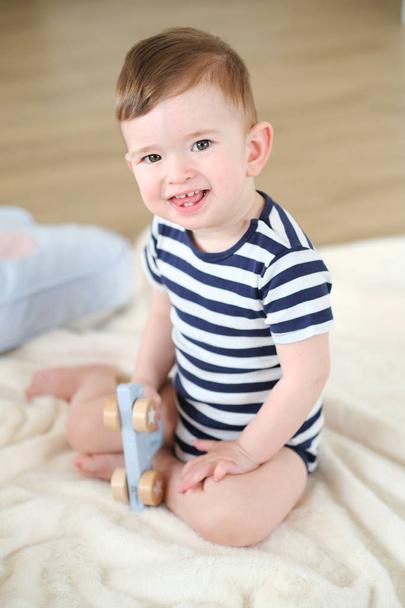 Baby Boy gra z drewnianych zabawek na podłodze. - Zdjęcie, obraz