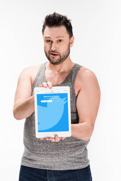 overweight man looking at camera and showing digital tablet with twitter app on screen isolated on white - Valokuva, kuva