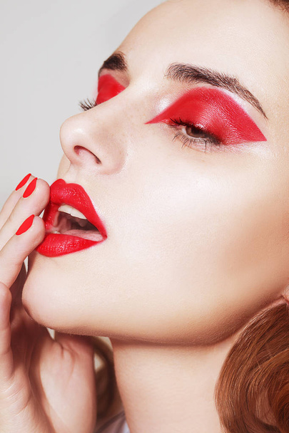 Schönheitsporträt von sexy Frauen mit Glamour-Make-up. Rote Lippen und rote Lidschatten. Schönheit Mode Modell Gesicht. Gepflegte Hand mit Nägeln. Frau mit Luxus-Make-up, perfekter Maniküre - Foto, Bild