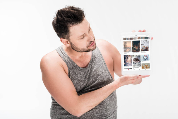 overweight man showing digital tablet with pinterest app on screen isolated on white - Fotó, kép