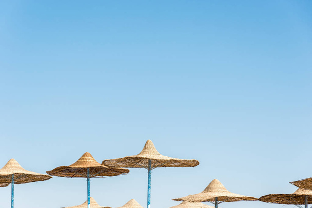 Lonely wicker sun umbrella at mediterranean beach by sea. Natura - Photo, Image