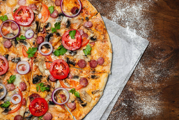 ahşap arka planda parşömen kağıt üzerinde lezzetli pizza - Fotoğraf, Görsel