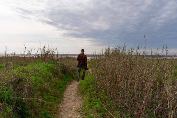 Fotógrafo de la naturaleza en acción caminando por un sendero cubierto de hierba Dres
 - Foto, Imagen