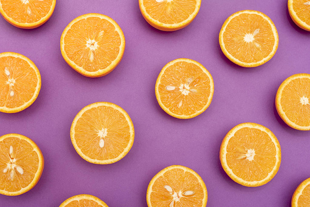 Naranjas jugosas de naranja divididas por la mitad en púrpura
 - Foto, Imagen