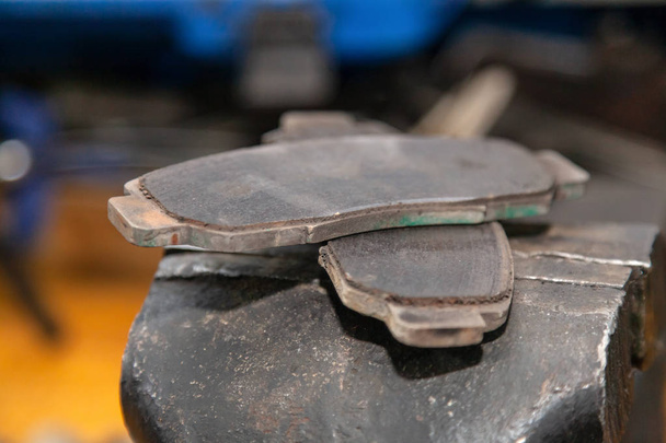 Un ensemble de deux vieilles plaquettes de frein automobile sur un garage
. - Photo, image