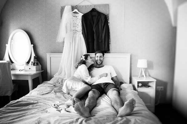 morning of the bride and groom, lovers lying and laughing in the bedroom, black and white photo  - Фото, изображение