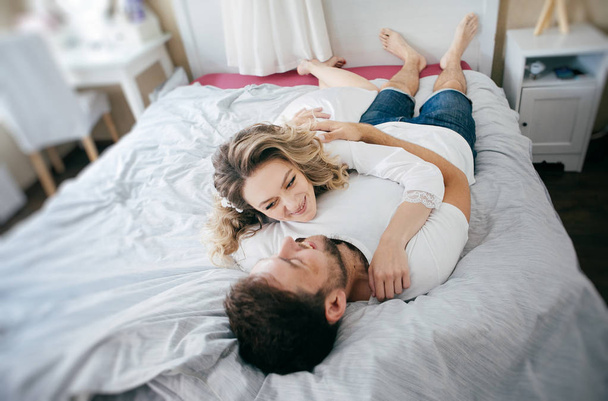 morning of the bride and groom, lovers lying and laughing in the bedroom - Fotoğraf, Görsel