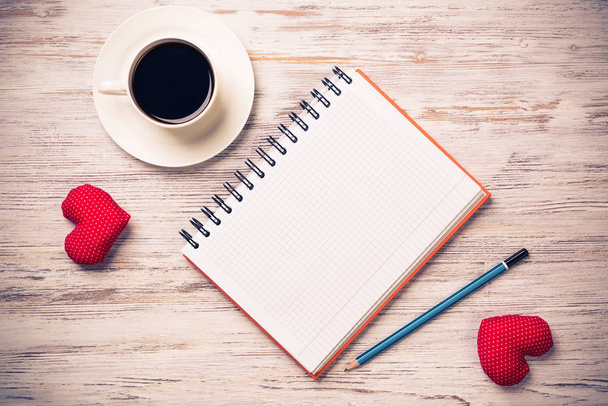 Kahve fincanı not defteri kalem ve ahşap yüzeyde iki kırmızı kalp - Fotoğraf, Görsel