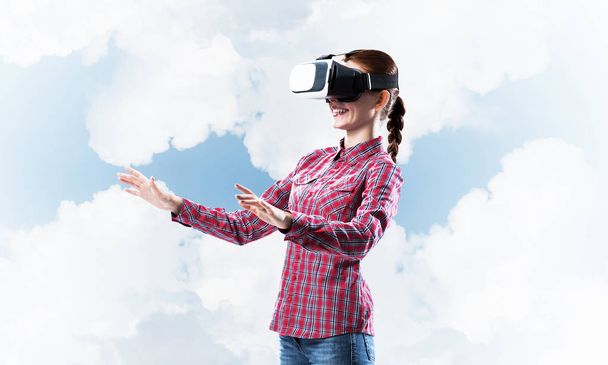 Young caucasian woman in virtual reality helmet against sky background - Valokuva, kuva