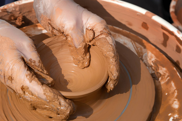 Руки Поттера работают с глиной на гончарном круге. Крупный план
 - Фото, изображение