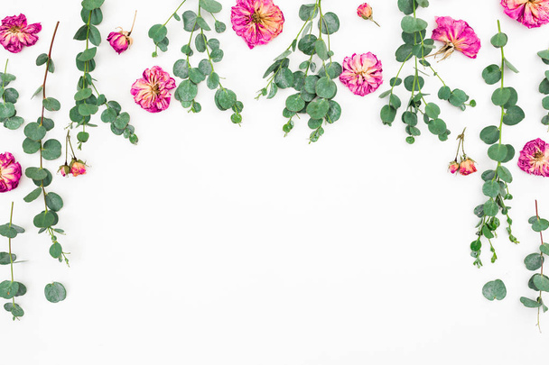 Virágos összetétele rózsaszín virágok és eukaliptusz fehér alapon. Lapos feküdt, felülnézet. Lemezterület másolása - Fotó, kép