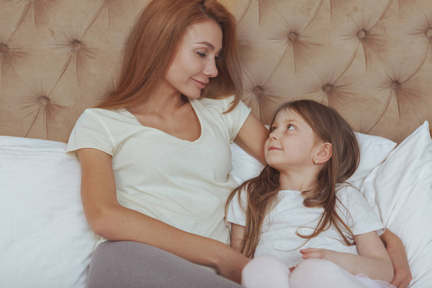 Happy mother and daughter resting at home together - Photo, Image