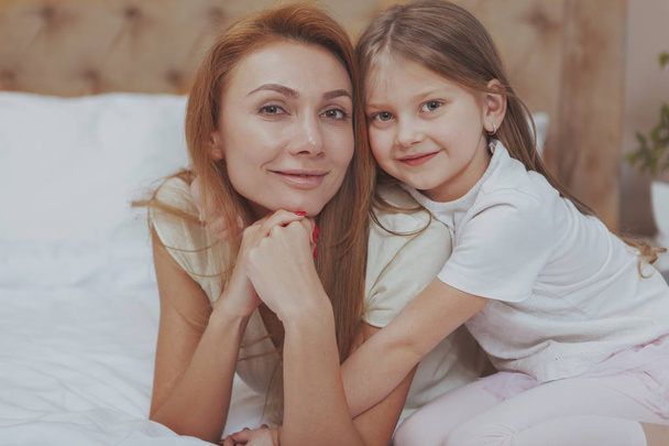 Happy mother and daughter resting at home together - Photo, Image