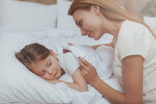 Lovely woman watching her daughter sleeping - Photo, Image