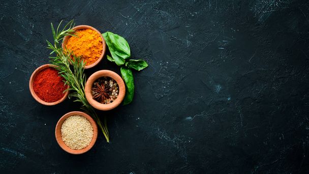 Colored spices on a black stone background. Free space for your text. Top view. - Фото, зображення