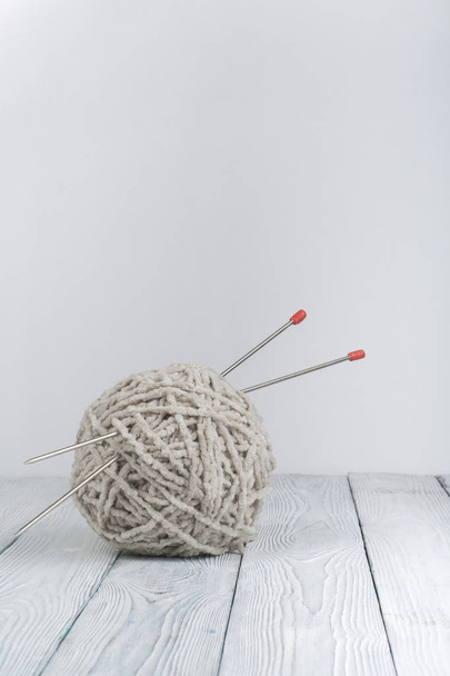 Ball of wool with spokes for handmade knitting on wooden table. Knitting wool and knitting needles - Foto, Bild