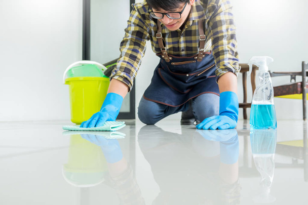 hombre con piso de limpieza de tela en el hogar utiliza trapo y fluido en una sp
 - Foto, Imagen