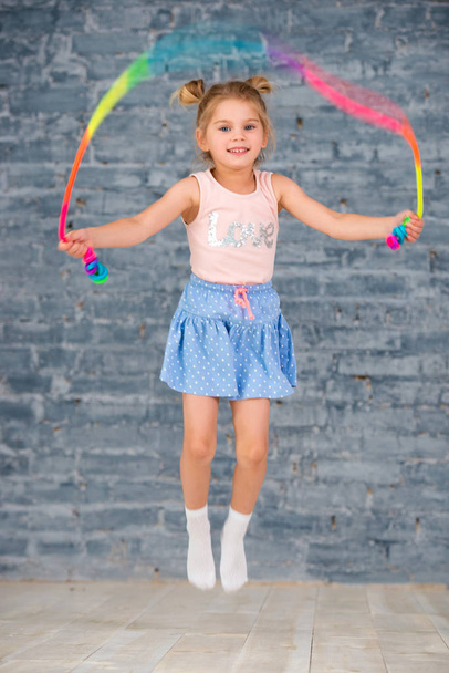 baby little cheerful girl jumping with rope - Zdjęcie, obraz