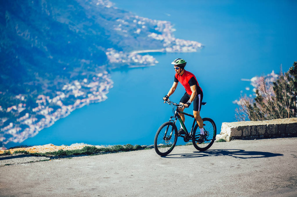 Homem andar de bicicleta de montanha na estrada. Esporte e vida ativa concep
 - Foto, Imagem
