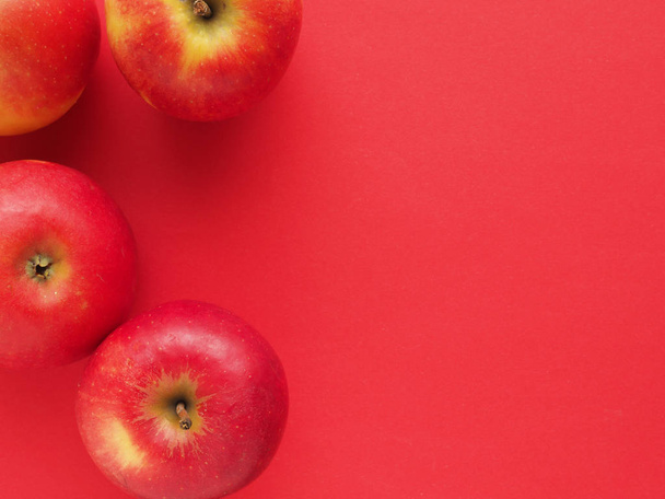 Red organic apples on a red background - Photo, Image